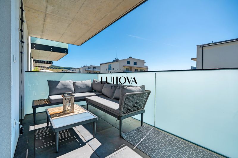 The balcony of a 3-room apartment on Dlhé lúky in Púchov with comfortable seating and a table.