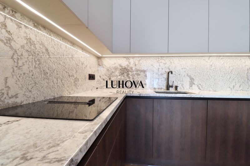 A kitchen with light stone cladding and a cooktop in a 3-room apartment.