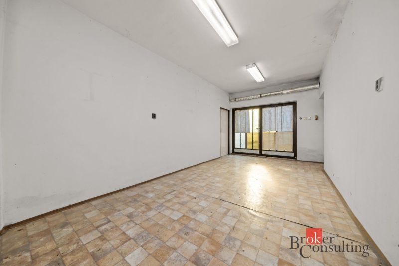 An empty room with windows and a wooden decor floor in a family house.