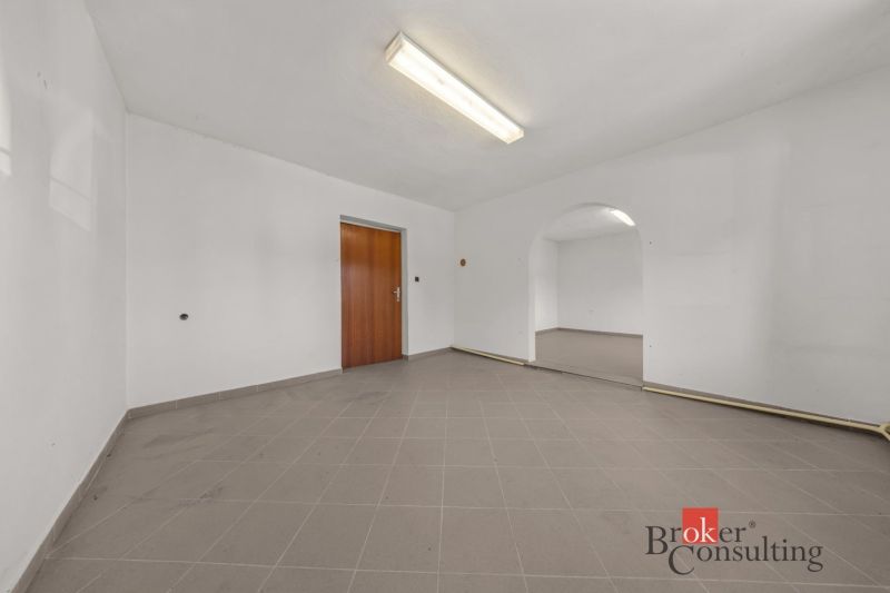 Interior of a family house with tiles and wooden doors, arched passage between rooms.