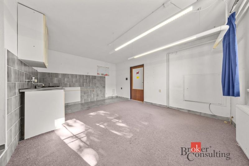 In the family house, there is a kitchenette with a sink and tile backsplash.