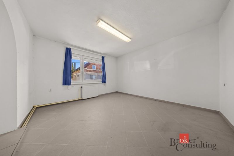 A spacious room with a window and curtains in a family house, tiled floor.