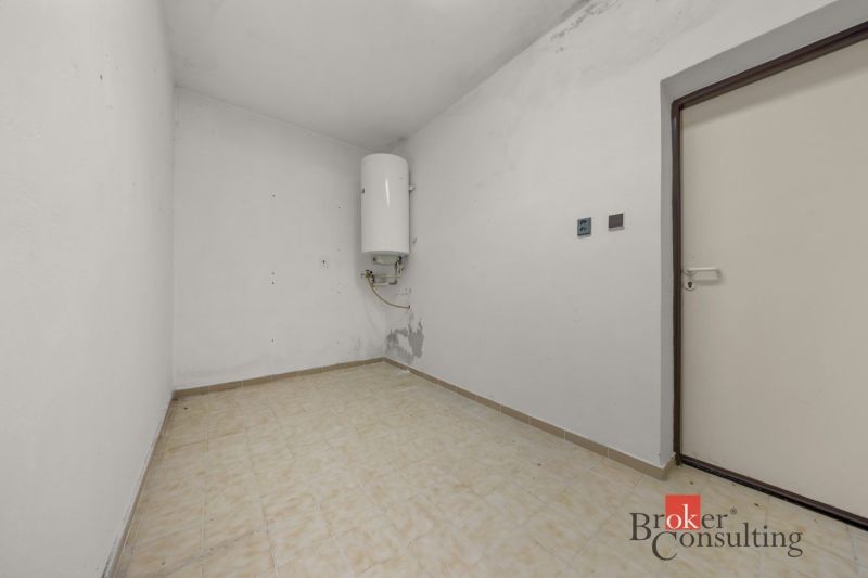 Empty room with a boiler and tiles in a family house.