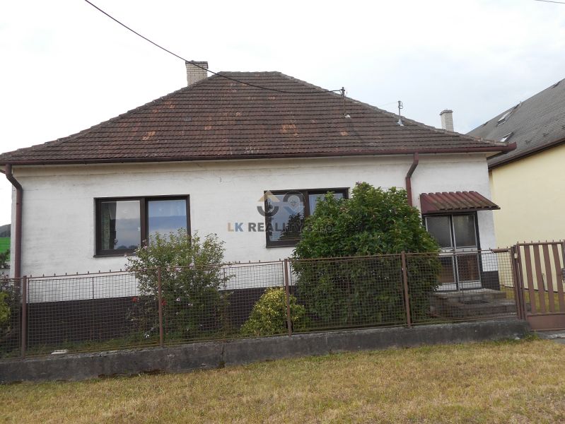 A family house in Trenčín with a white facade, a garden, and a sloped roof.