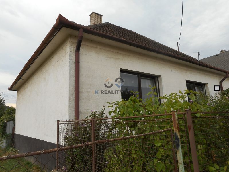 A family house in Trenčín with a fence and a garden, windows with brown frames.