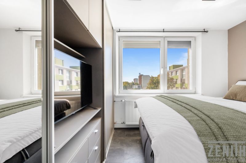Bedroom with a bed, television, and a view from the window, 2-room apartment.