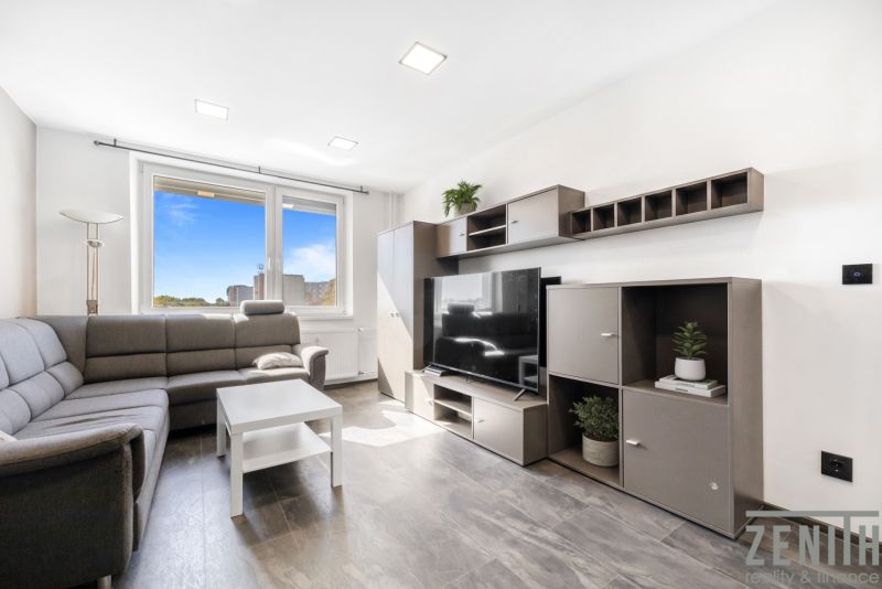 Living room in a two-room apartment with a corner sofa and a large window.