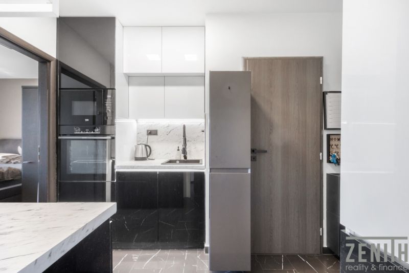 A kitchen in a 2-room apartment with white and black cabinets.