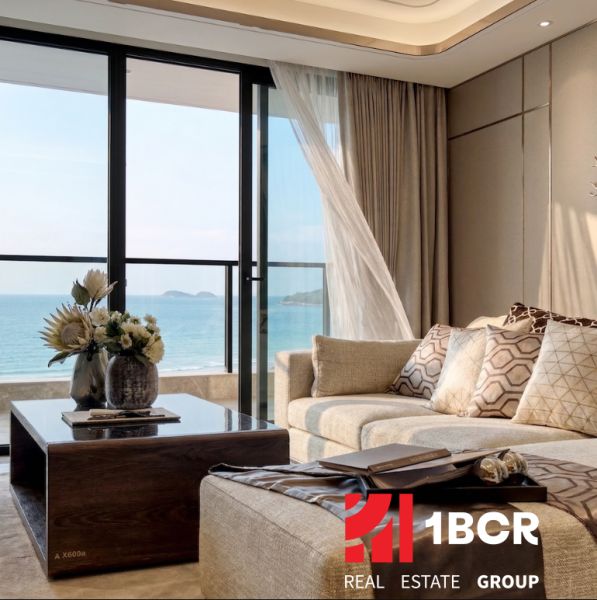 Living room in a 3-room apartment with a view of the sea and a wooden decor floor.