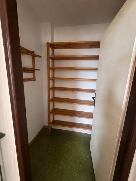 Storage space with shelves and a green floor in a 3-room apartment.