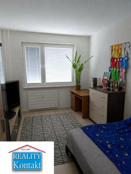 A room in a 2-room apartment with a desk and decorative ribbons on the wall.