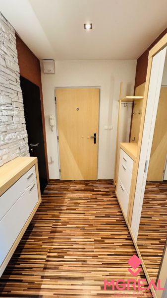 Entrance area of a 3-room apartment with wood-patterned flooring and storage spaces.