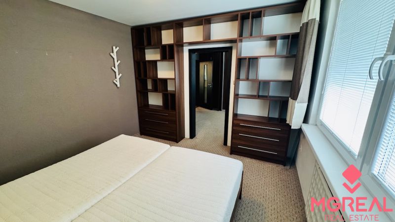 Bedroom in a 3-room apartment with shelves and a large window.