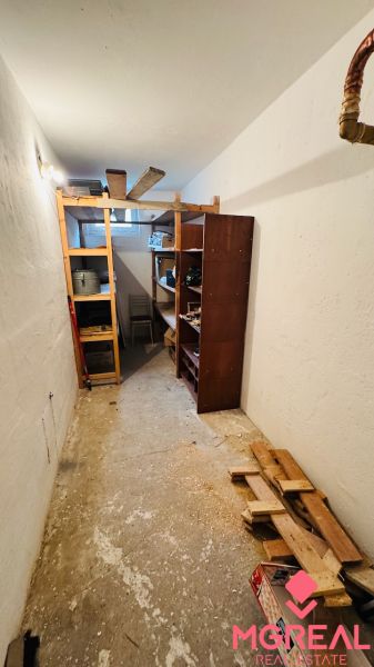 Storage space in a 3-room apartment with shelving units and building materials.
