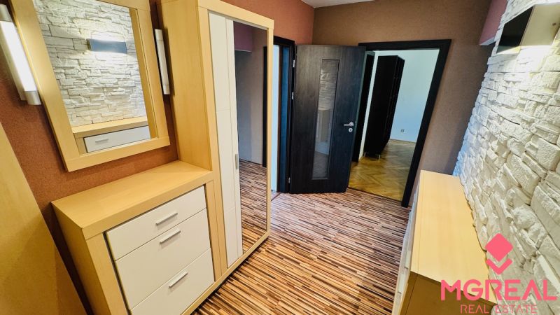 Entrance hall with wood-patterned flooring and stone cladding in a 3-room apartment.