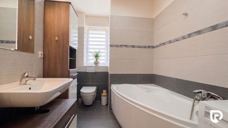 A bathroom with a bathtub and a sink in a 2-room apartment, bright tiles.