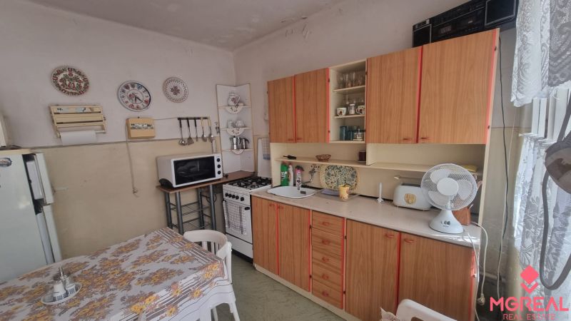 A kitchen in a family house with decorative plates and traditional wooden furniture.