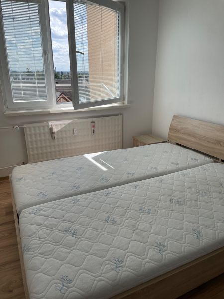 A bed with orthopedic mattresses and a floor with a wooden decor in a studio apartment.