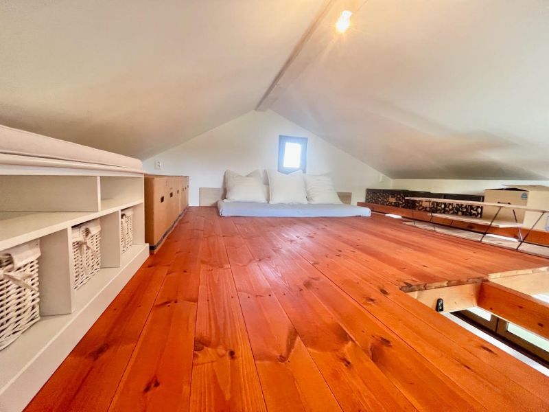 Wooden decor flooring, beds, and storage boxes in the attic.