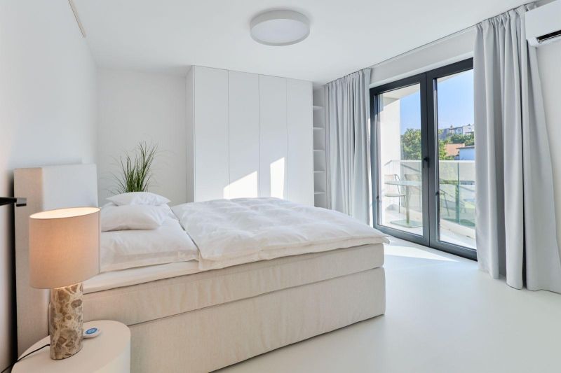 Bright bedroom with a built-in wardrobe, bed, and balcony doors in a 4-room apartment.