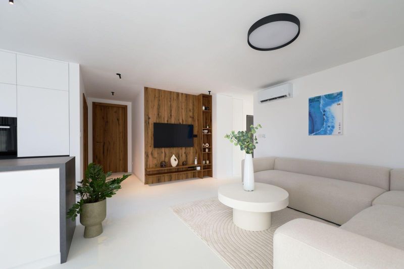Living room in a 4-room apartment with a wooden decor floor, light seating, and decorations.