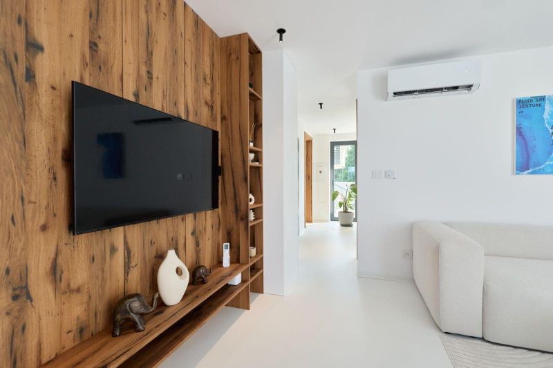 Living room with wood-patterned flooring and a TV in a 4-room apartment.