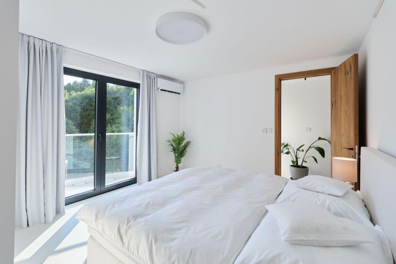 A bright bedroom with a bed, balcony, and plant in a 4-room apartment.