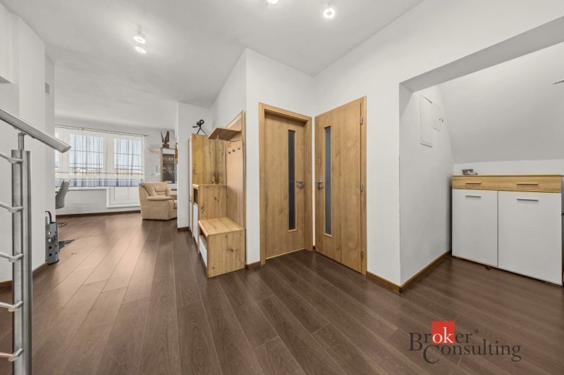 The entrance hall of a 4-room apartment with a wooden decor floor and wooden furniture.