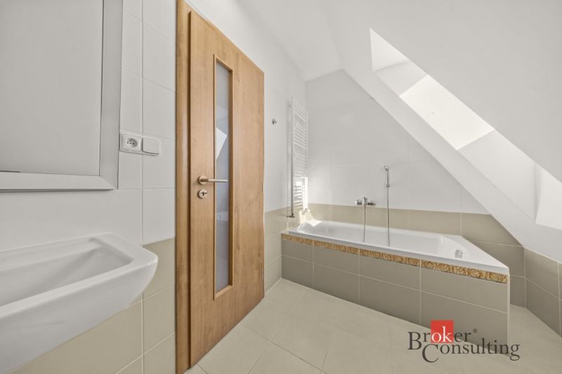 Bathroom in a 4-room apartment with light fixtures, a bathtub, and wooden doors.