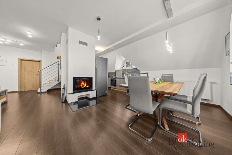 Dining area with a table, chairs, and a fireplace, floor with wood decor.