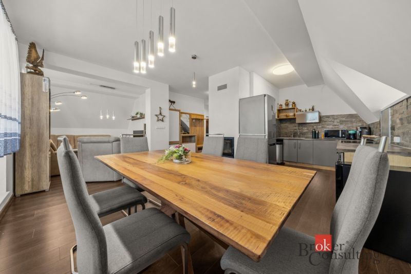 Dining area in a 4-room apartment with wood-patterned flooring and modern lights.