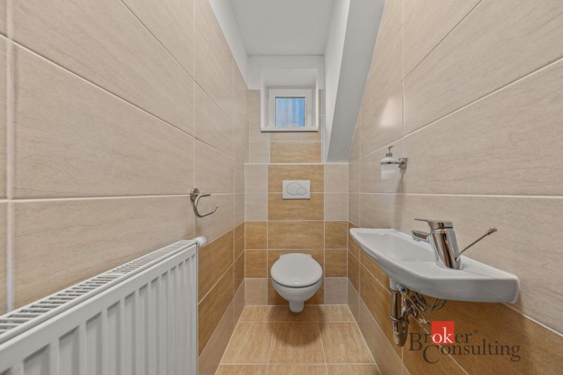 A bathroom in a 4-room apartment with a sink and a small window.