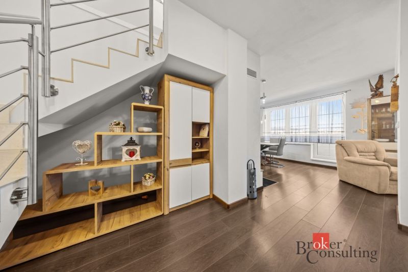 Interior of a 4-room apartment with a wooden decor floor, stairs, and an open living area.