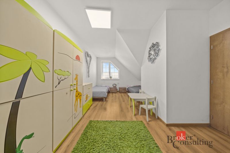 Children's room with wood-patterned flooring, green carpet, and safari-themed furniture.