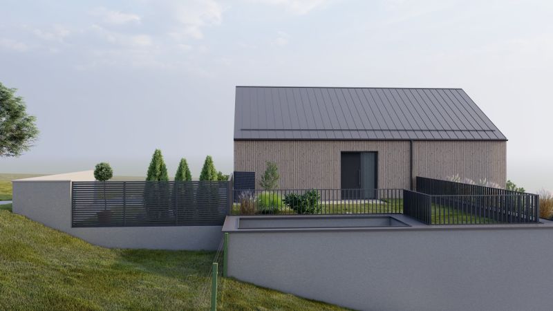 A family house in Staškov with sloping terrain and a modern fence.