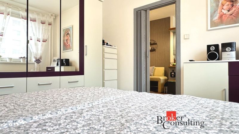 A bedroom in a 3-room apartment with a mirrored wardrobe and interior decorations.