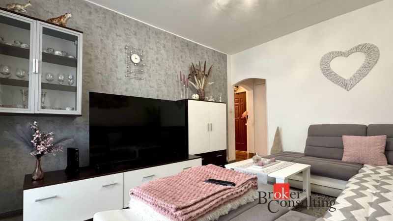 Living room in a 3-room apartment with decorations, a couch, and a television.
