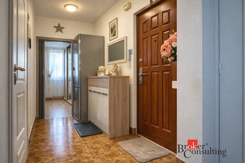 Hallway in a 3-room apartment with an entrance door, a wardrobe, and tiles.