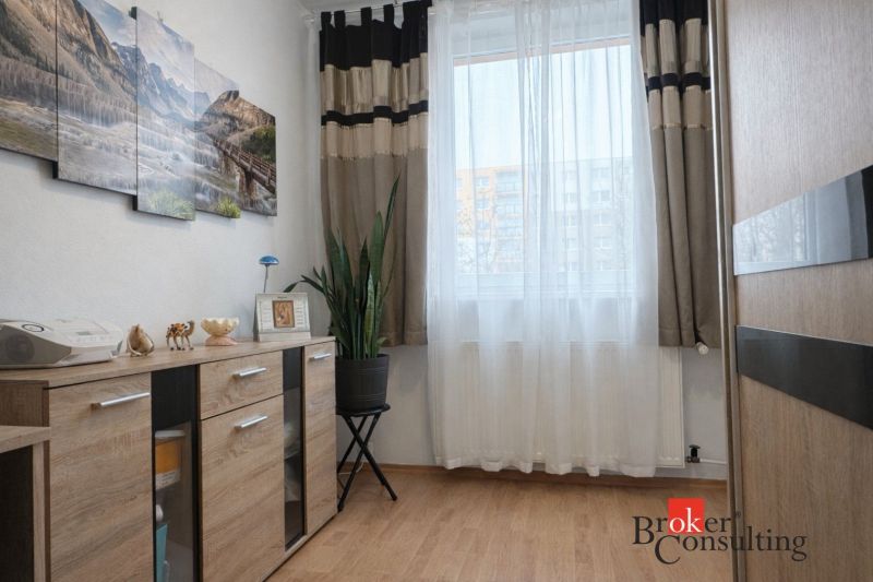 Living room in a 3-room apartment with a wooden decor floor and decorations.