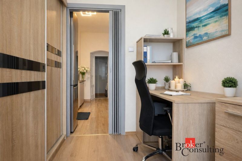 A workspace in a 3-room apartment with a wooden decor floor and office furniture.