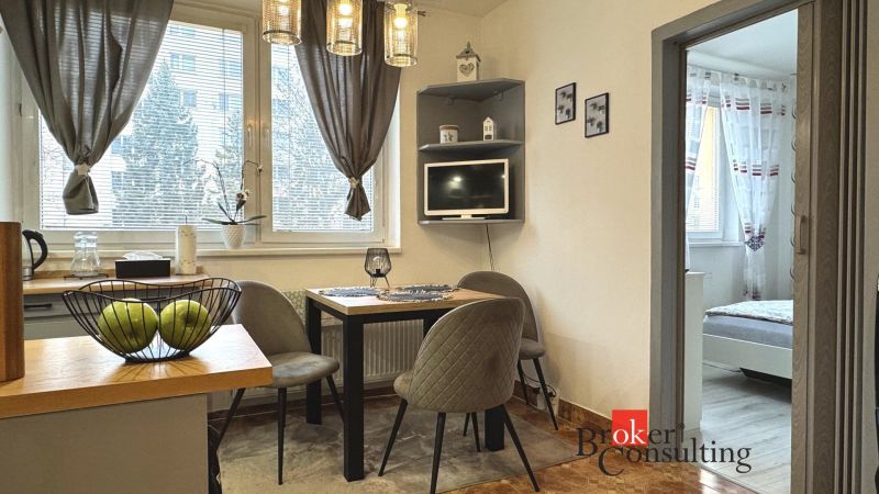 Dining area with a table and chairs, next to the entrance to the bedroom in a 3-room apartment.
