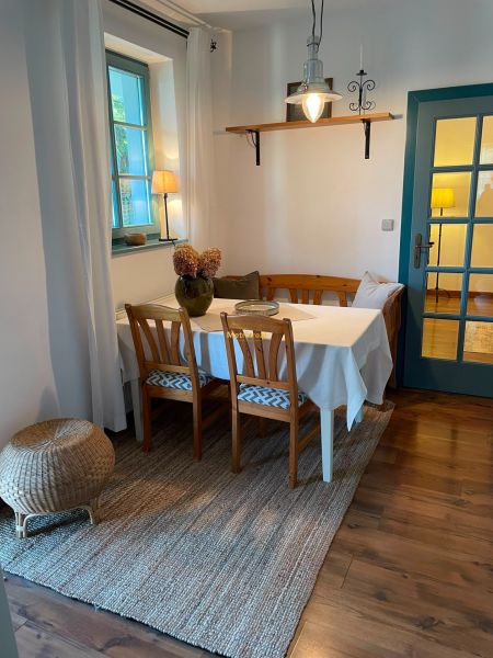Dining area with wooden furniture and wood-patterned flooring in a family house.