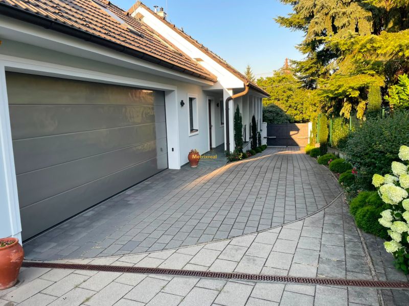 A family house in Bratislava - Dúbravka with a garage, paving, and a well-maintained garden.