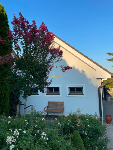 A family house in Bratislava - Dúbravka with a bench and flowers in front of it.