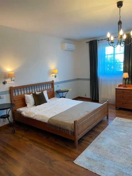 A bedroom in a family house with a comfortable bed and a wooden decor floor.