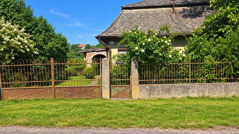 A family house in Ľuba at the address Ľubá 143 with an ornamental garden and flowers.