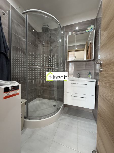 A bathroom with a shower in a 2-room apartment with practical storage space.