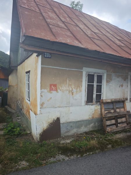 A family house in Špania Dolina with an older facade and a sloped metal roof.