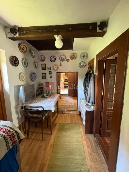 The interior of a cottage with decorative plates on the walls and a floor with a wooden decor.
