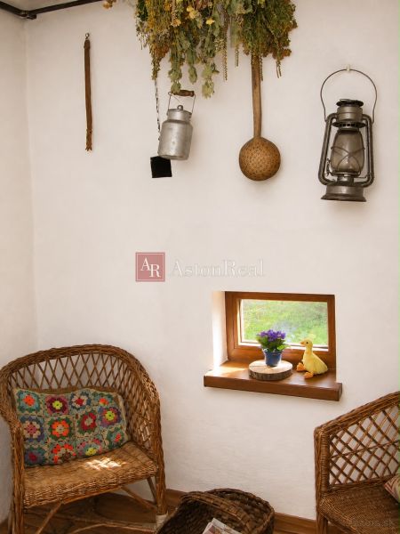 Interior of a cabin with rattan chairs, wood-patterned flooring, and rustic decor.